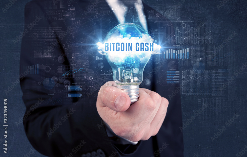 Businessman holding a light bulb with BITCOIN CASH inscription, new business concept Businessman holding a light bulb with BITCOIN CASH inscription, new business concept