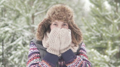 Beautiful frozen woman drinks warm tea in winter forest photo