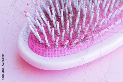 pink comb on a pink background with fallen hair photo