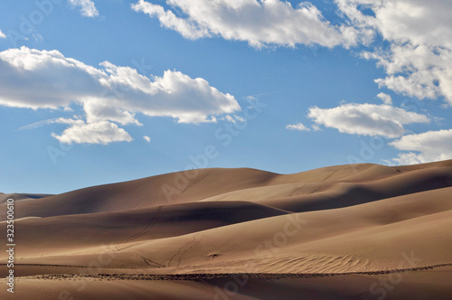A lone hiker walks the ridge at Great Sand Dunes National Park on a sunny day