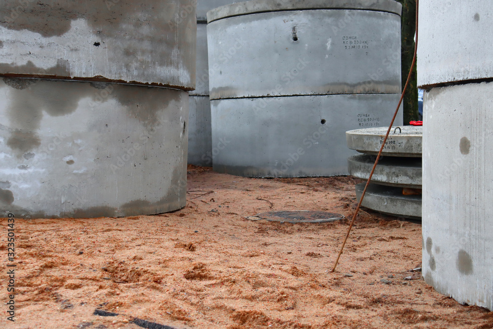 Construction concrete rings on the sand. Material for laying the pipeline on the ground. Construction concrete rings on the sand. Material for laying the pipeline on the ground.