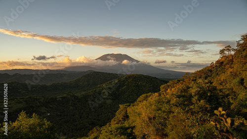 Green hills with volcano and clouds on background