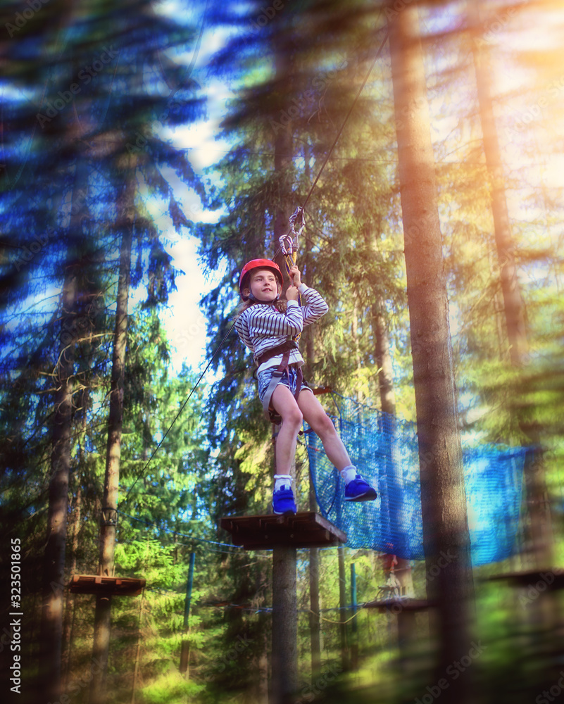 Fototapeta young girl rides down a zipline