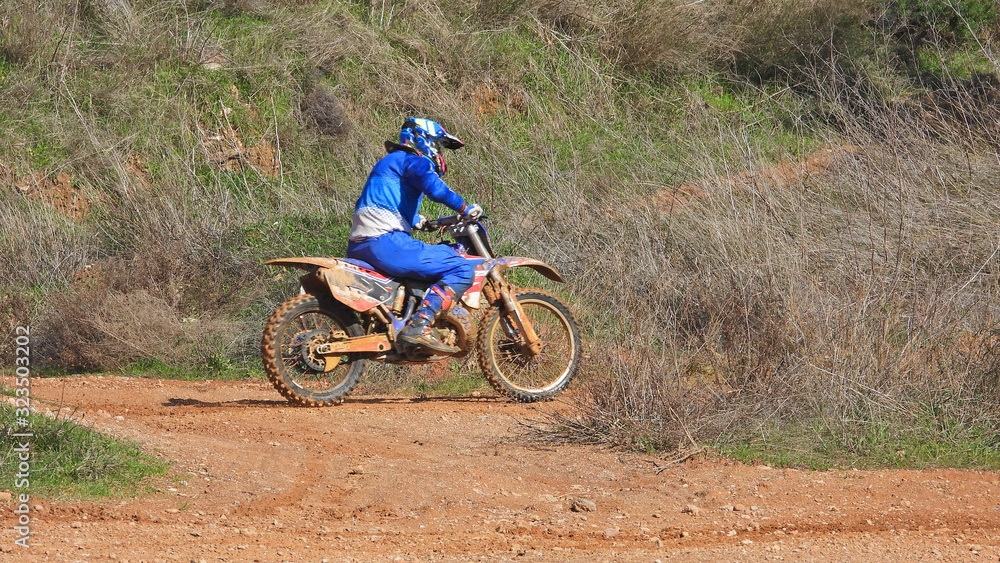 Zoom photo of mud track enduro motocross rider performing freestyle stunts in high speed Zoom photo of mud track enduro motocross rider performing freestyle stunts in high speed