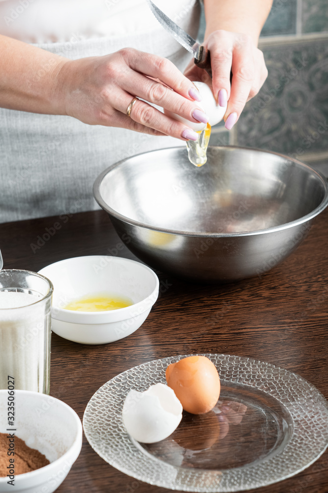 The recipe for making muffins. Ingredients for making muffins. A woman is cooking pastries. The cook breaks the egg with a knife. The recipe for making muffins. Ingredients for making muffins. A woman is cooking pastries. The cook breaks the egg with a knife.