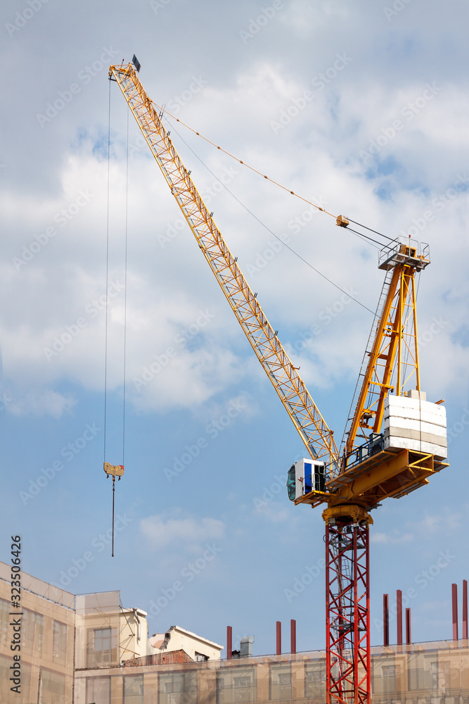 Crane and workers at construction site against blue sky. Crane and workers at construction site against blue sky.