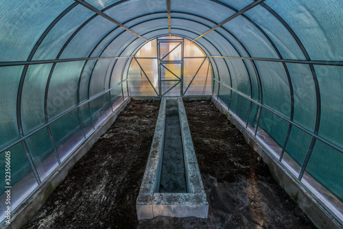 Interior of empty greenhouse before spring with concrete walls