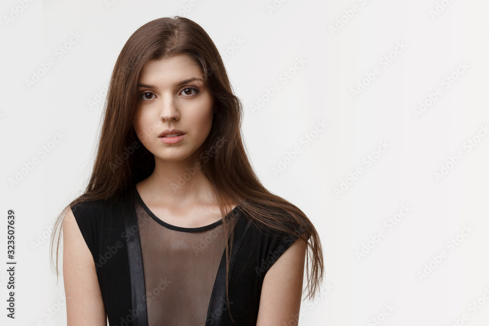 Splendid girl with long hair and natural make up, skin care, in black sexy blouse, over white background. Copy space. Splendid girl with long hair and natural make up, skin care, in black sexy blouse, over white background. Copy space.