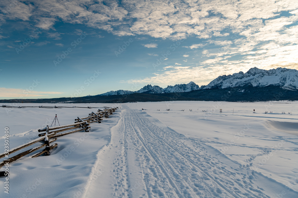 Winter trail foot path covered with snow and mountain range Winter trail foot path covered with snow and mountain range