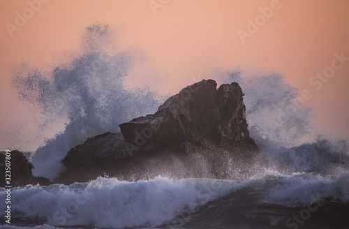 Fotografija Wild Waves hitting a Rock in a beautiful sunset