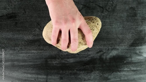 Male hand hold big stone. Top view. Close up.