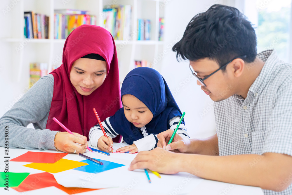 Asian muslim family drawing on origami papers Asian muslim family drawing on origami papers