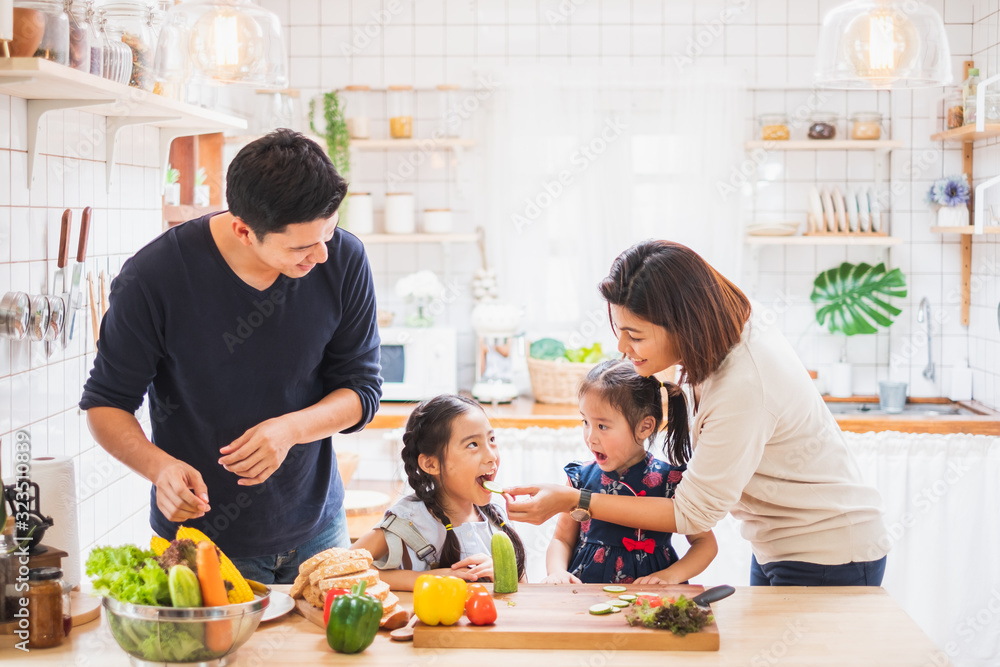 Asian family enjoy playing and cooking food in kitchen at home