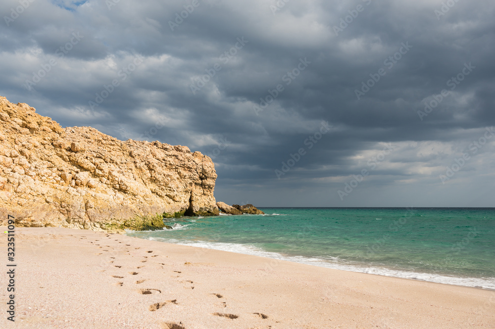 Sandy beach with turquoise water and dramatic dark clouds Sandy beach with turquoise water and dramatic dark clouds