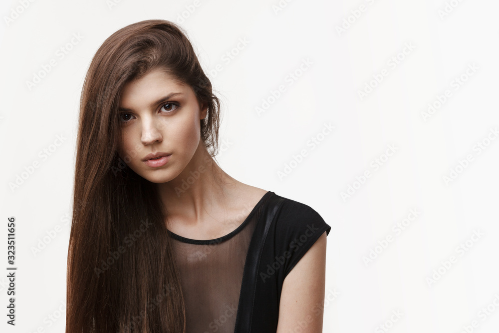 Girl with long hair, without makeup, with well-groomed skin, looks at the front, posing in the studio on a white background. Space for text. Girl with long hair, without makeup, with well-groomed skin, looks at the front, posing in the studio on a white background. Space for text.
