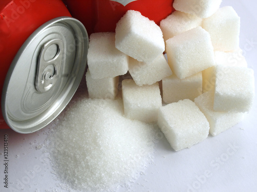sugar adiction: close up of red soda softdrink cans and sugar