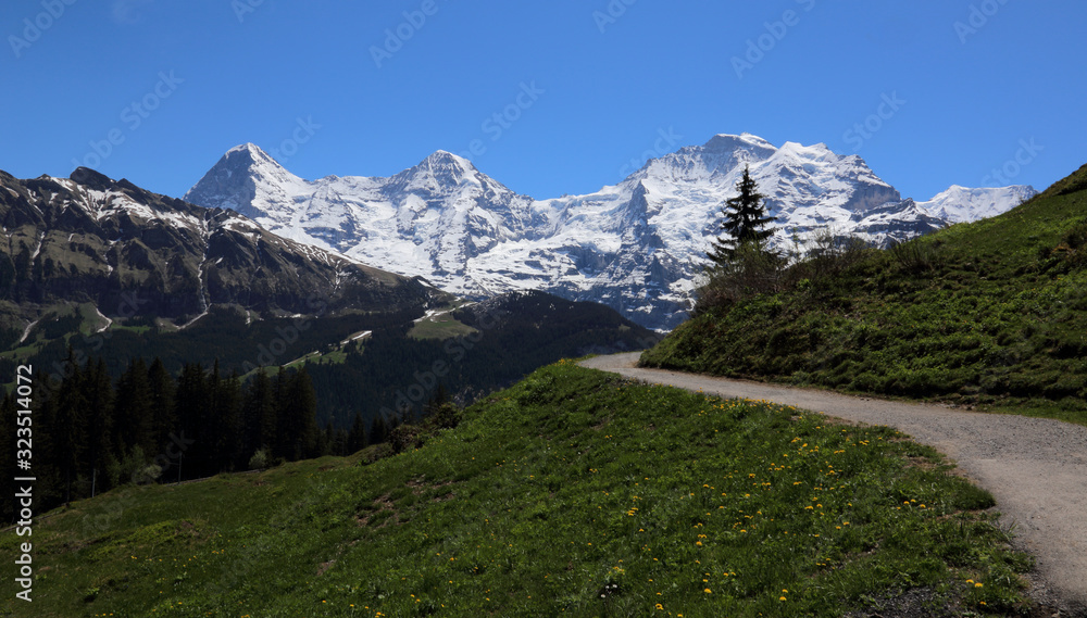 The trail to Murren with Eiger, Monch and Jungfrau on the horizon in the Bernese Alps, Switzerland.