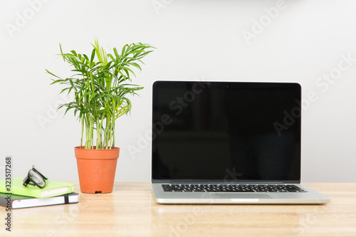 Front view of creative designer desktop with laptop ,notebook , supplies.