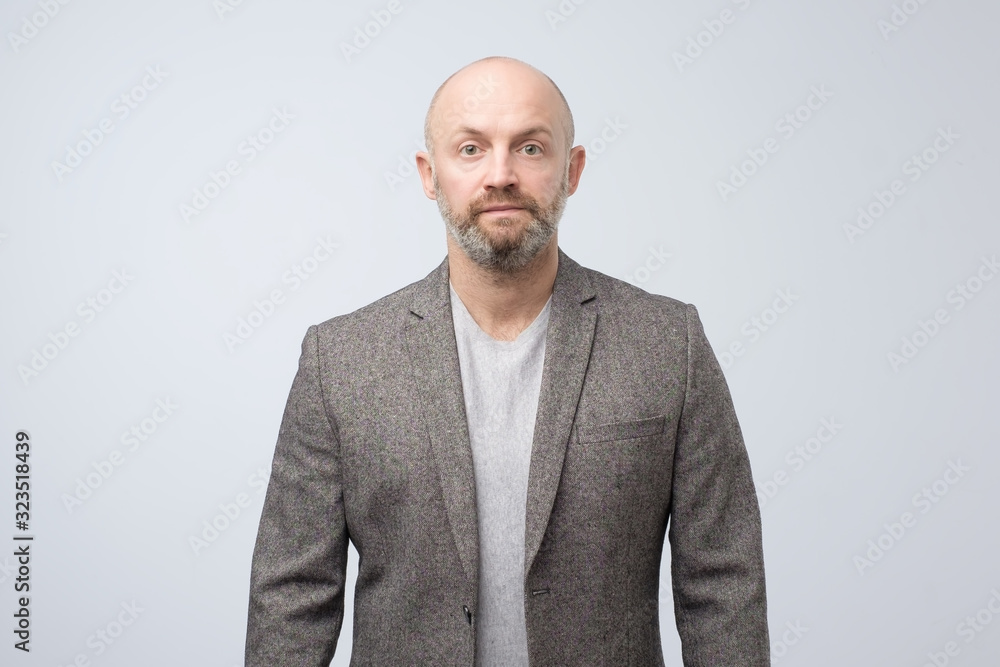 Confident mature man with beard looking at camera with serious face. Studio shot Confident mature man with beard looking at camera with serious face. Studio shot