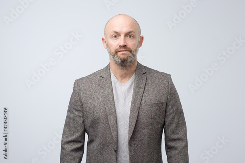 Confident mature man with beard looking at camera with serious face. Studio shot © Viktor Koldunov