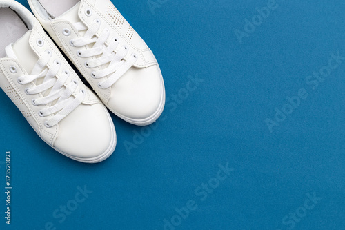 White sneakers on blue backfground. Copy space. Life style