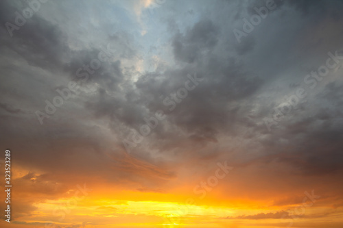 Sunset sky covered with orange puffy clouds in the evening.