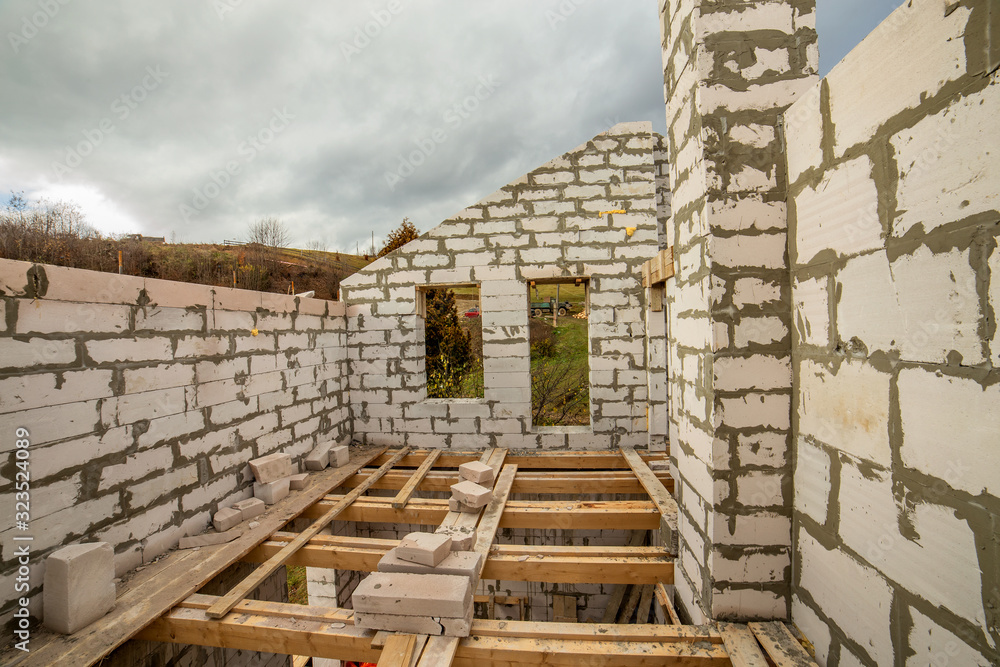 Building site of a house under construction made from white foam concrete blocks. Building site of a house under construction made from white foam concrete blocks.