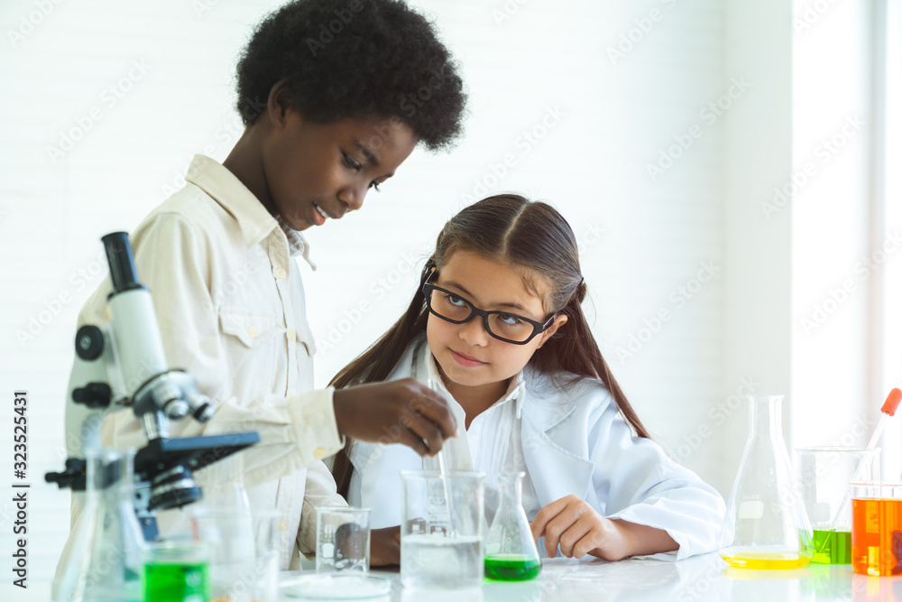 Asian school kid or scientist studying science AND experimenting with chemicals at laboratory. Asian school kid or scientist studying science AND experimenting with chemicals at laboratory.