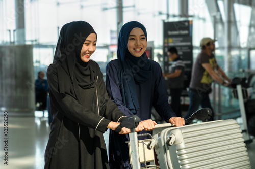 travel, tourism, flight and people concept - muslim woman in hijab bright smile with luggage at airport , trip for woman concept.