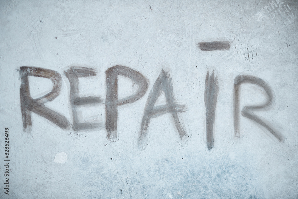 Background image of REPAIR word on concrete wall in house under construction, copy space Background image of REPAIR word on concrete wall in house under construction, copy space