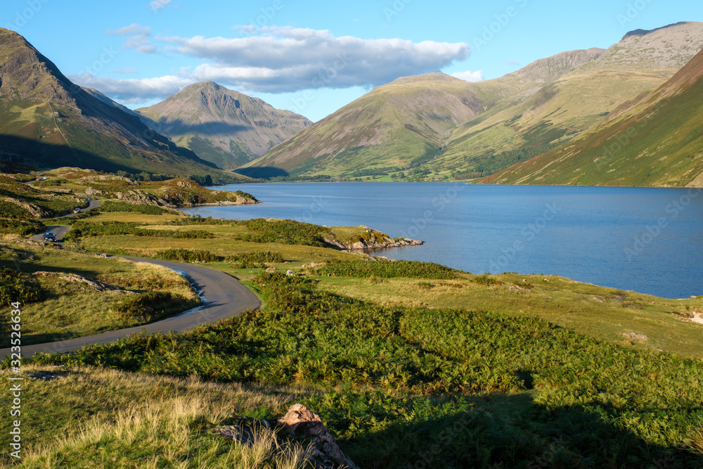 Winding roads towards Wasdale head and Scafell Pike on a summer afternoon with blue skies and calm water