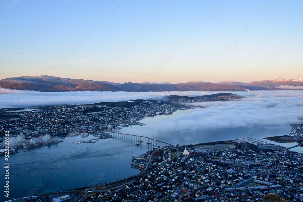 A beautiful cityscape of Tromso (including the Artic Cathedral) with low altitude cloud taken from Fløya during sunset