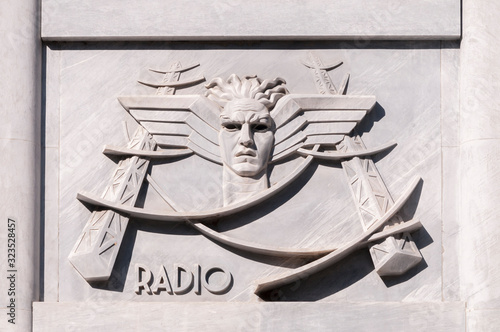 Bas-relief in fascist style depicting the telegraph service, on the facade of the central post office in Carrara, Italy. photo