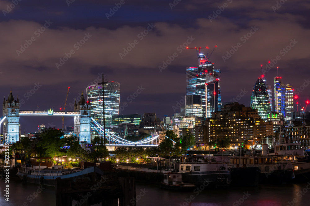 A photograph of the The City of London and Tower Bridge taken from the bank of the River Thames