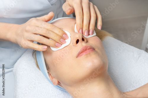 Close-up beautician doctor hand making anti-age procedure  mask and peeling for young attractive female client at beauty clinic. Cosmetologist specialist doing skincare treatment .Health care therapy