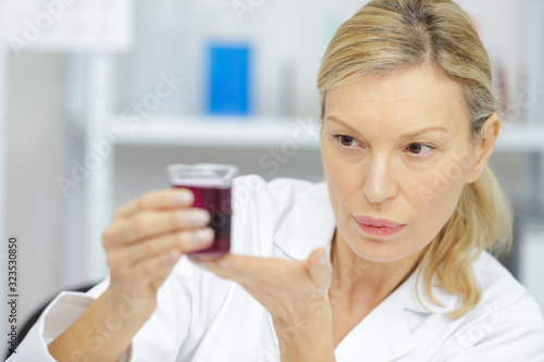 female senior looking at flask indoors