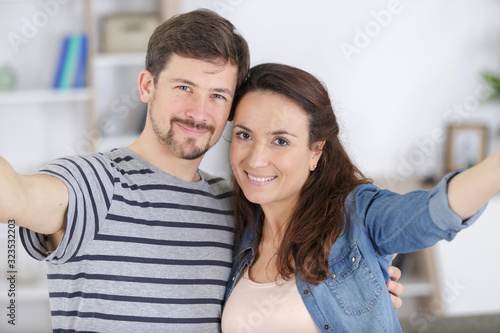 happy young married couple makes a selfie in new apartment