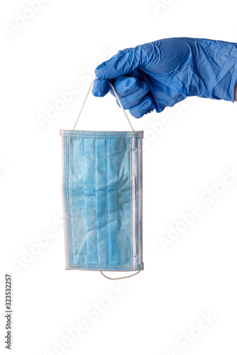 Female hand in blue medical glove holding protective face mask isolated on white background. Coronavirus and flu virus protection concept. Epidemic prevention. Close-up