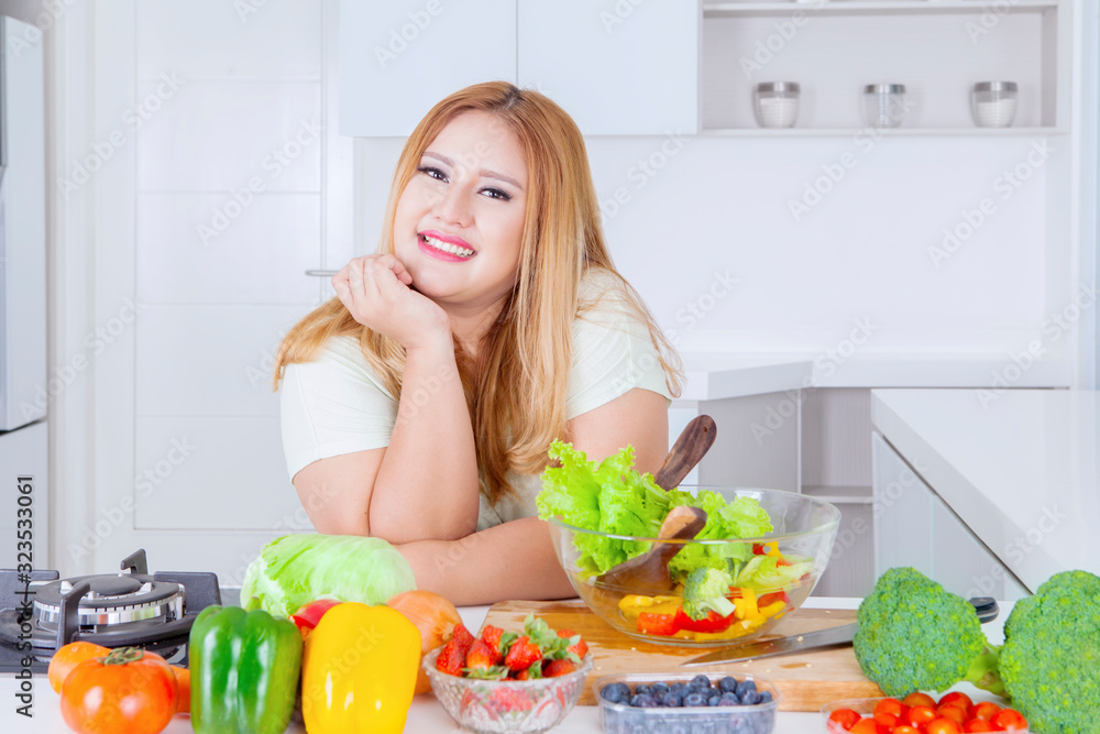 Blonde overweight woman smiling in kitchen Blonde overweight woman smiling in kitchen