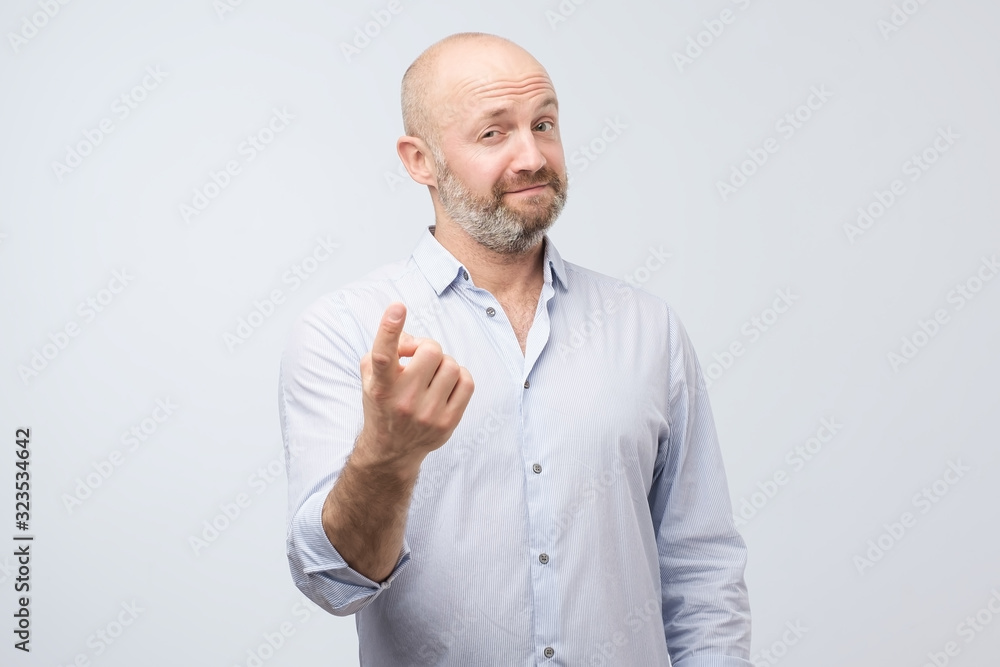 Handsome mature man showing come here gesture. Studio shot Handsome mature man showing come here gesture. Studio shot