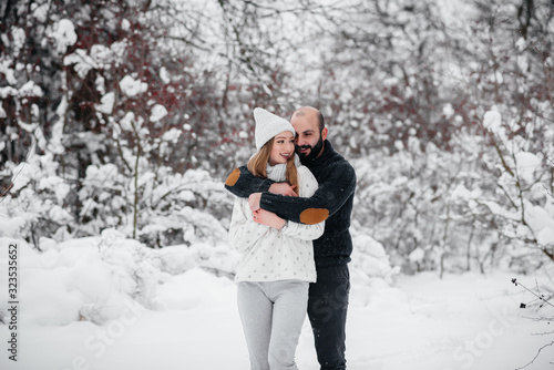 Couple playing with snow in the forest