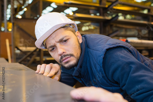 Fotografie man placing sheetmetal onto a pallet
