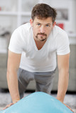 healthy man doing side plank exercise on a mat