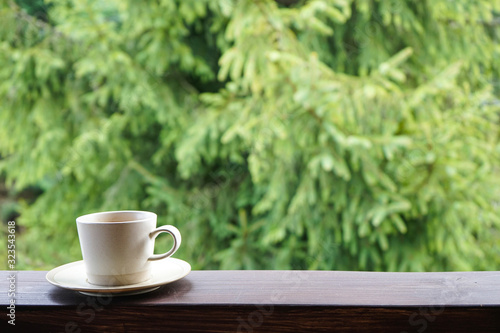 A cup of tea on the railing of the terrace, with place for text. Morning concept. Close-up. 