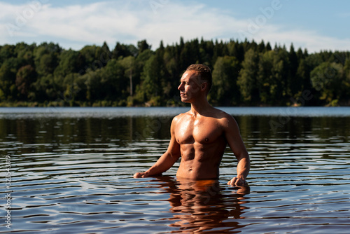 A beautiful muscular man on a lake in the water.