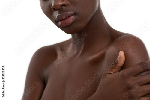 Dark skin model. Cropped photo of african woman standing against white background. Beauty concept