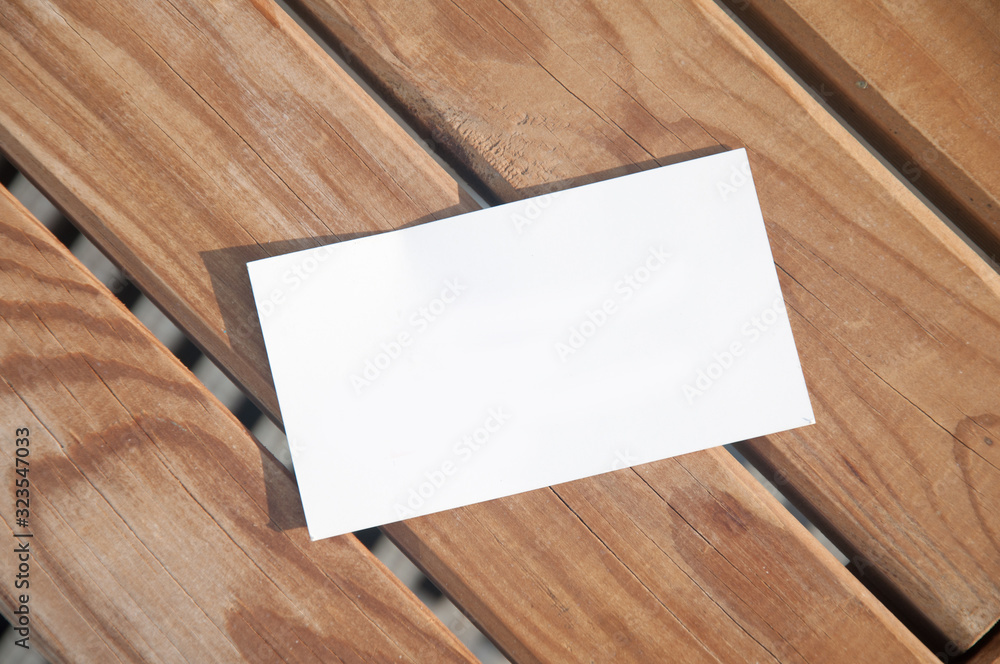 White paper card lying on wooden boards. Top view White paper card lying on wooden boards. Top view