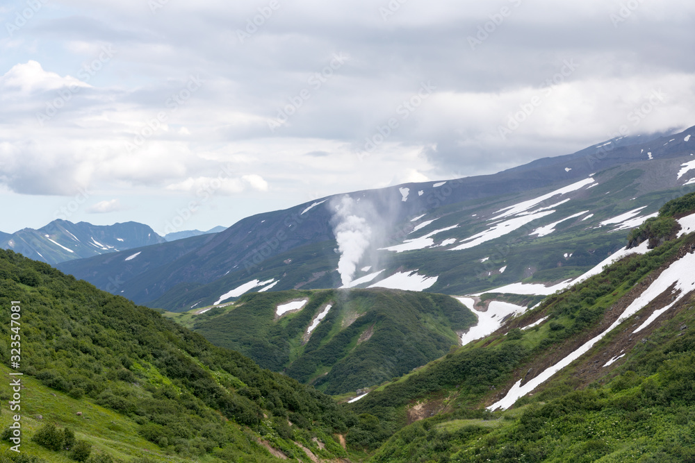 Obraz premium Small Valley of Geysers, Kamchatka Peninsula, Russia. This is a unique active fumarole field, the hot gases of which pass through the water of a cold stream, heating it and creating a gushing effect.
