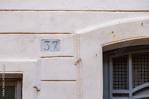 number 37, ancient house number plate on brick wall, Italy