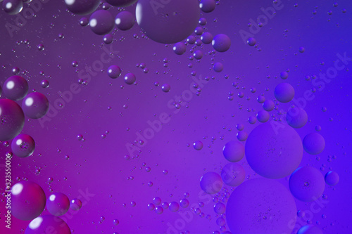 Oil drops on water surface color abstract background. blue and pink circles